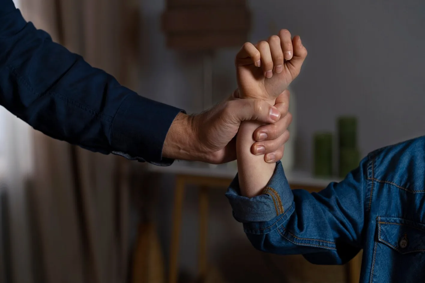 A man's hand gripping a child's wrist