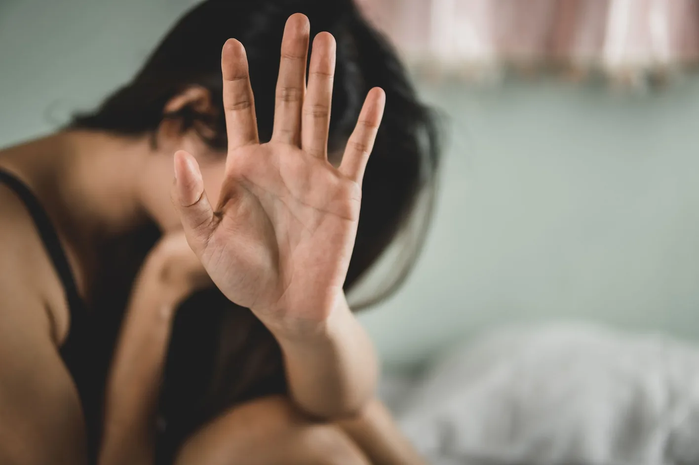 A distressed woman holding up her hand to say stop